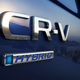 A photo of the logo on a blue Honda CR-V Hybrid SUV.